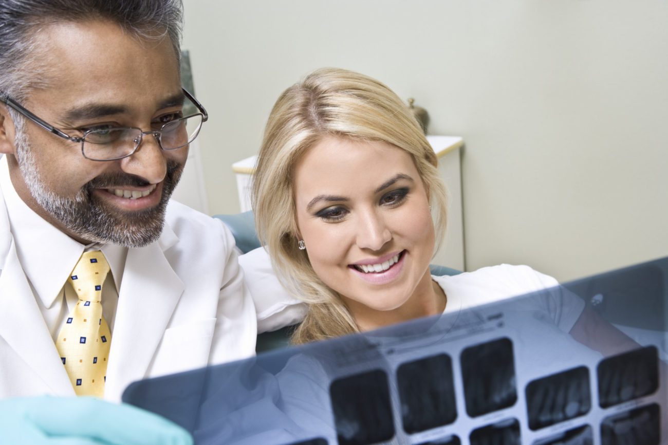 Dentist and patient looking at x-ray tooth extraction marrero la